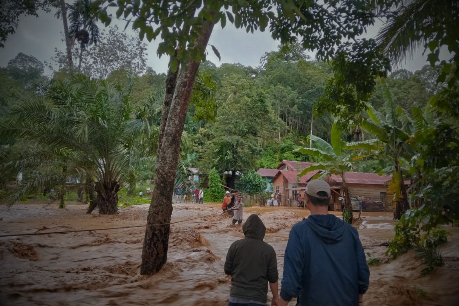warga menerjang arus banjir di banjir sumatera